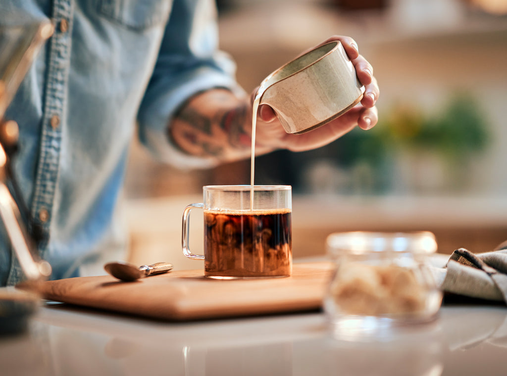 Bringing out the best in your coffee, and image of a person's hand pouring cream into a cup